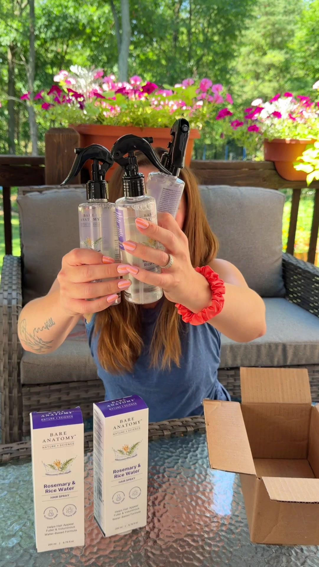 Customer unboxing three bottles of hair spray