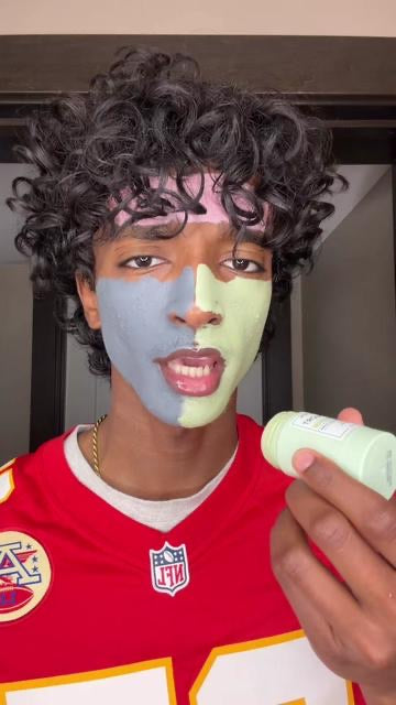 Customer wearing a green clay mask and holding the Mugwort clay stick