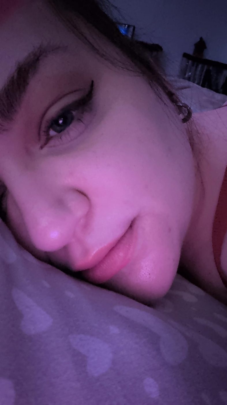 Low-light customer selfie showing a finished eyeliner look.