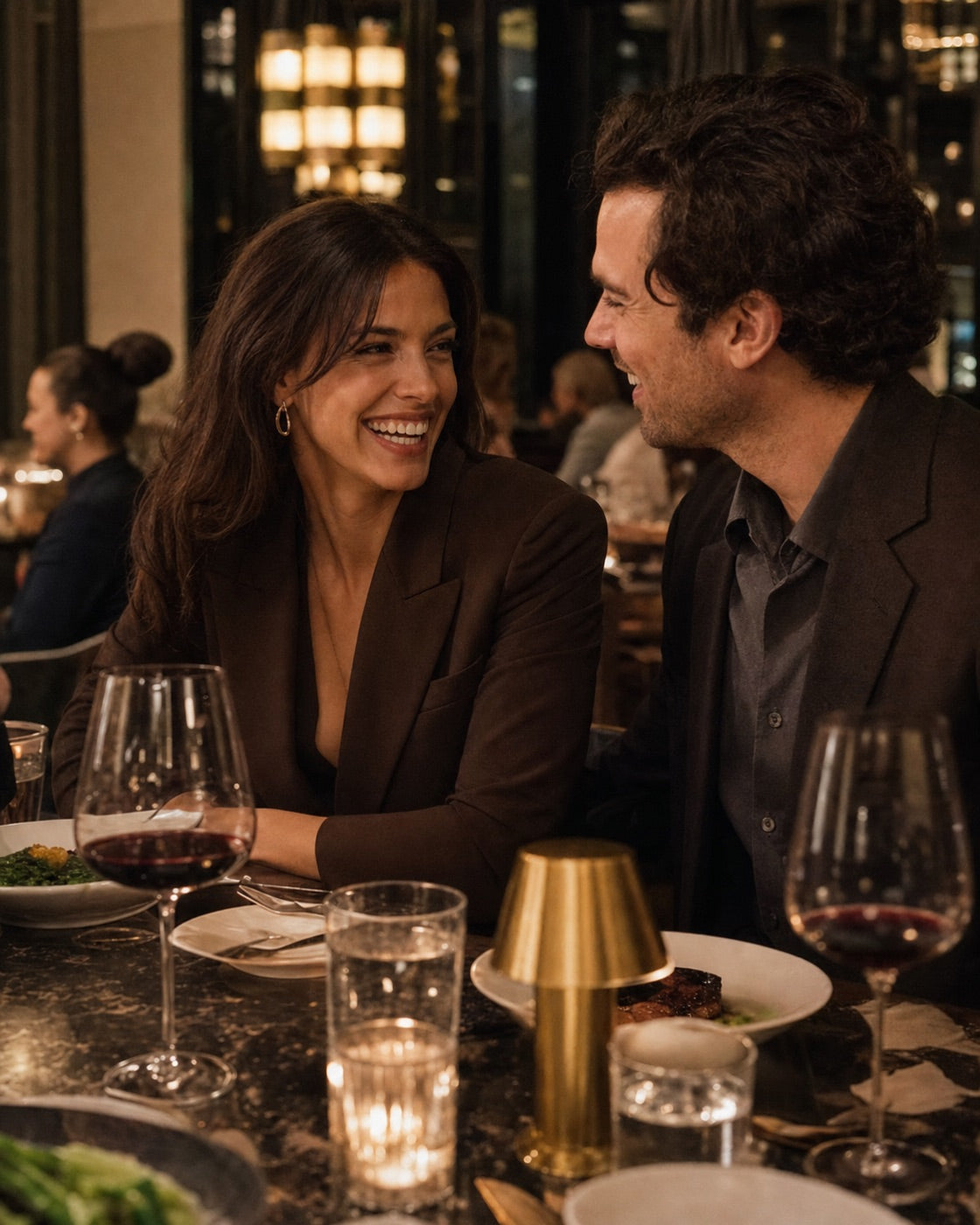 Two adults enjoying a close conversation over dinner