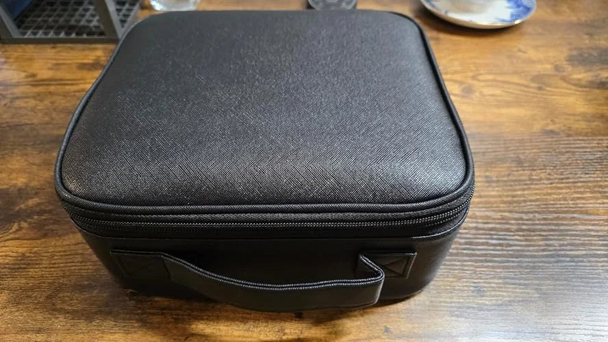 Customer photo of the black makeup case resting closed on a wooden table